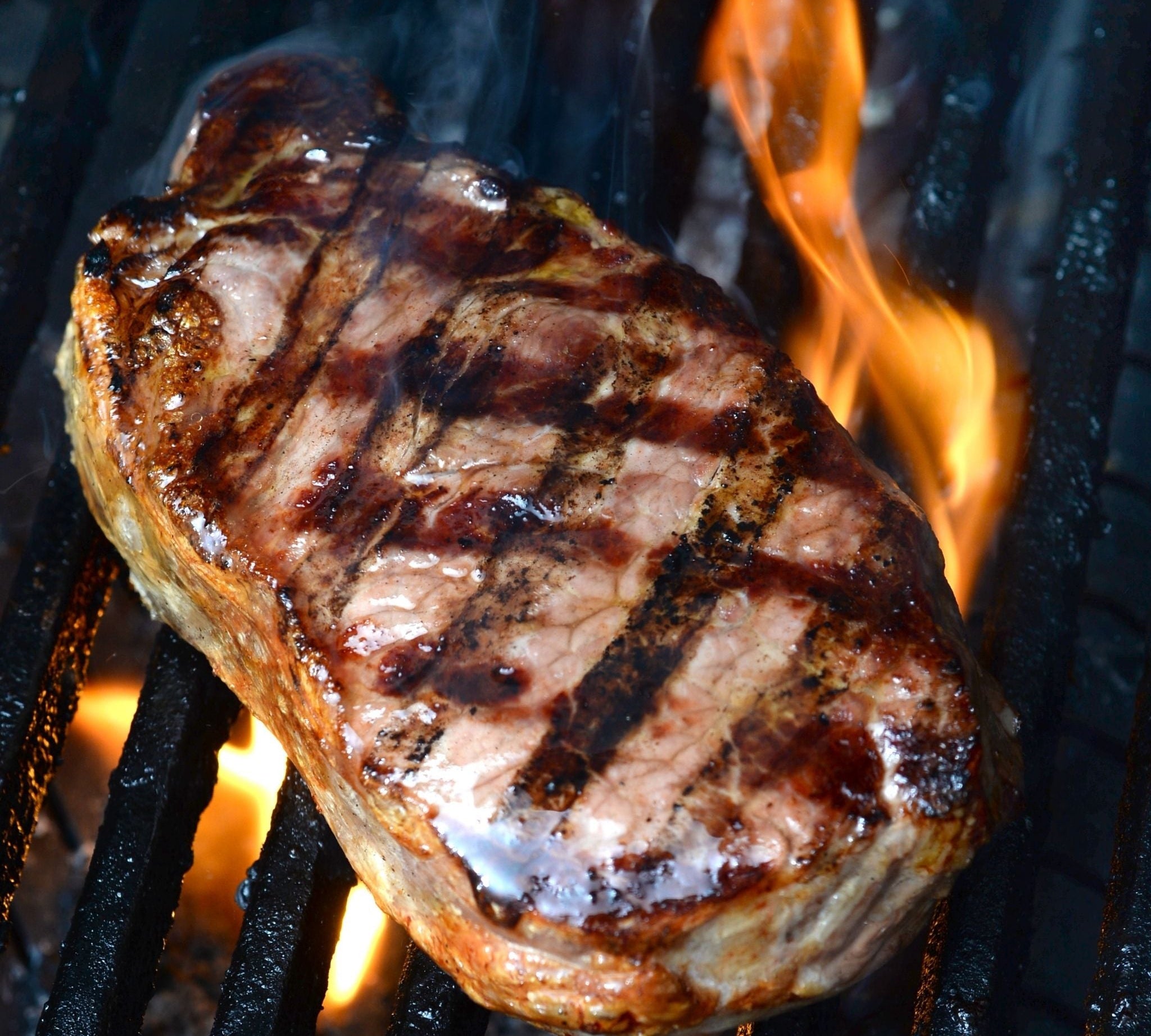 Farm88 porterhouse steak on a flaming BBQ grill